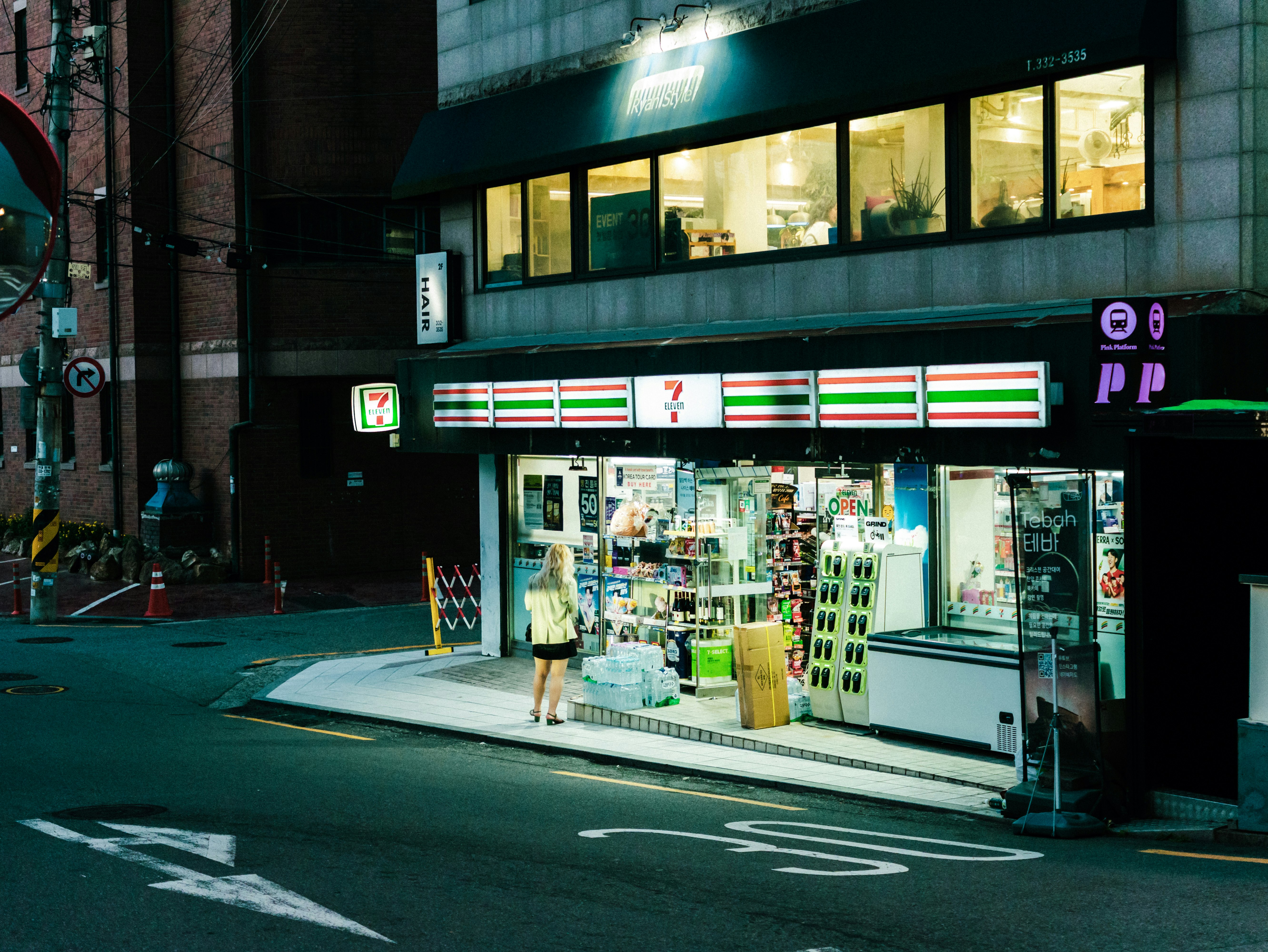 ネオン看板のある夜の路地に面した小さな店舗の外観