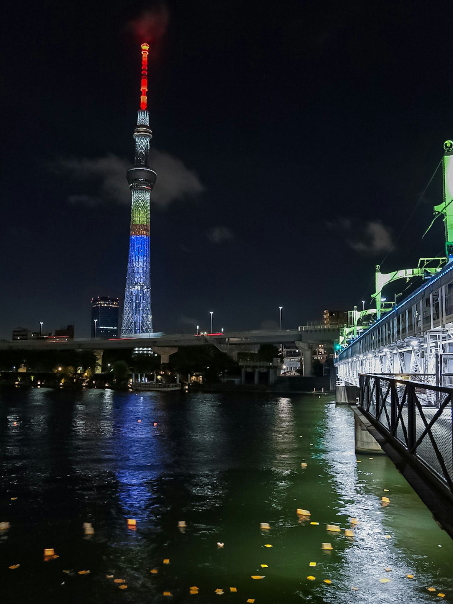 Tokyo Skytree iluminado por la noche con reflejos en el agua