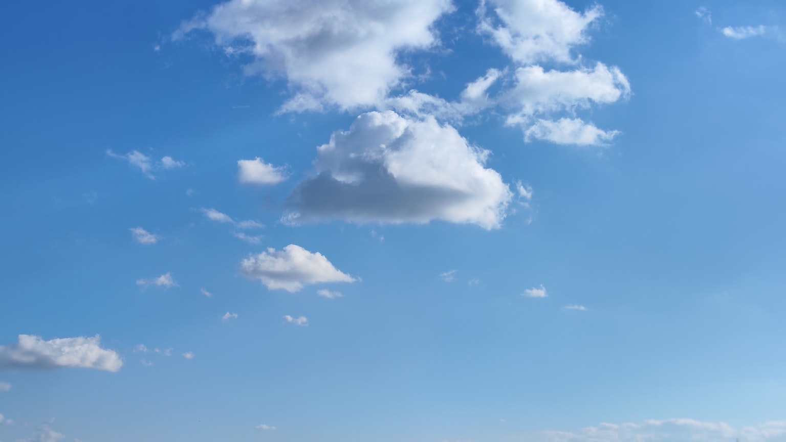 Un paesaggio di nuvole bianche che fluttuano in un cielo blu