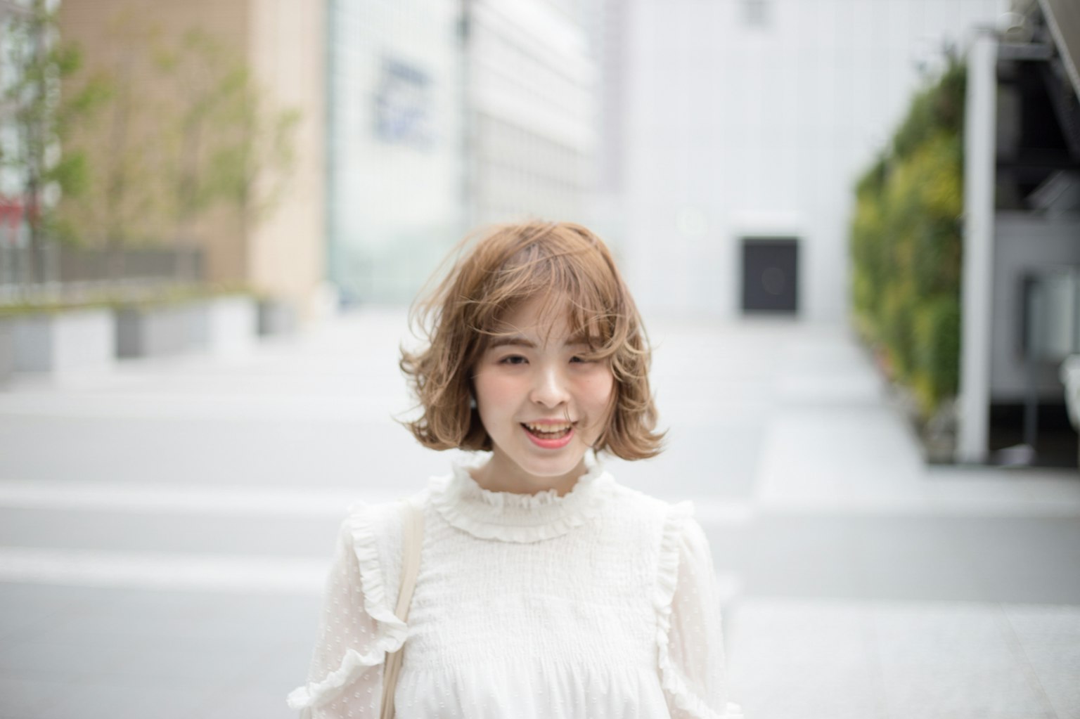 穿着白色上衣的女性在城市背景前微笑