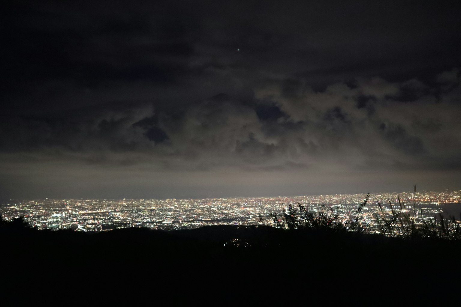 Nächtliche Stadtlandschaft mit Stadtlichtern und bewölktem Himmel