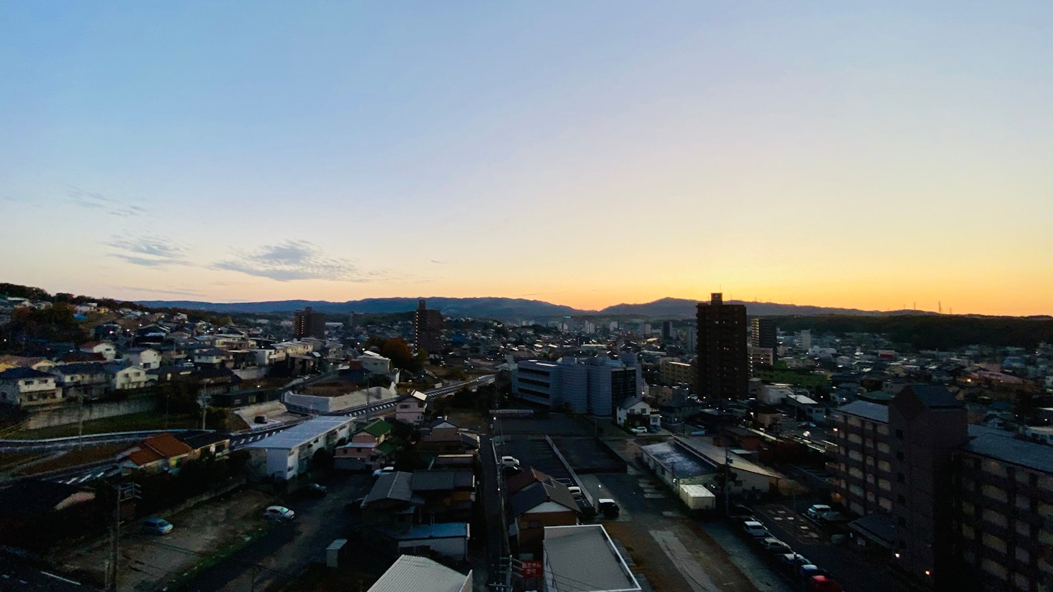 Stadtlandschaft bei Dämmerung mit sichtbaren Bergen und Gebäuden