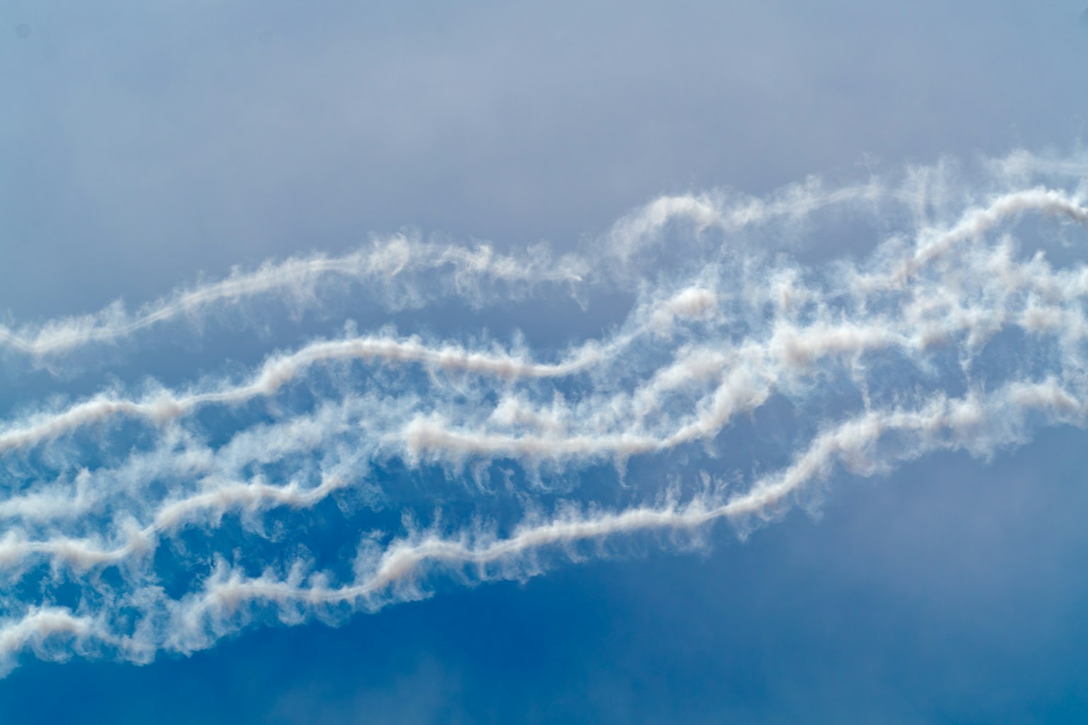Jejak putih bergelombang di langit biru
