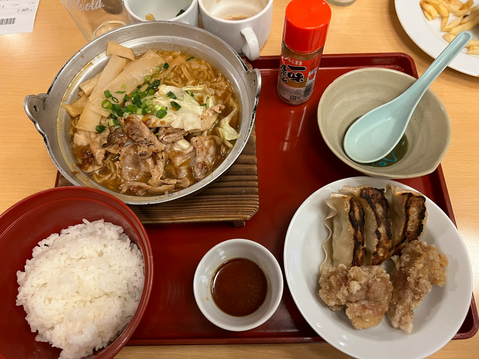 A warm pot dish with rice set featuring meat, vegetables, and condiments
