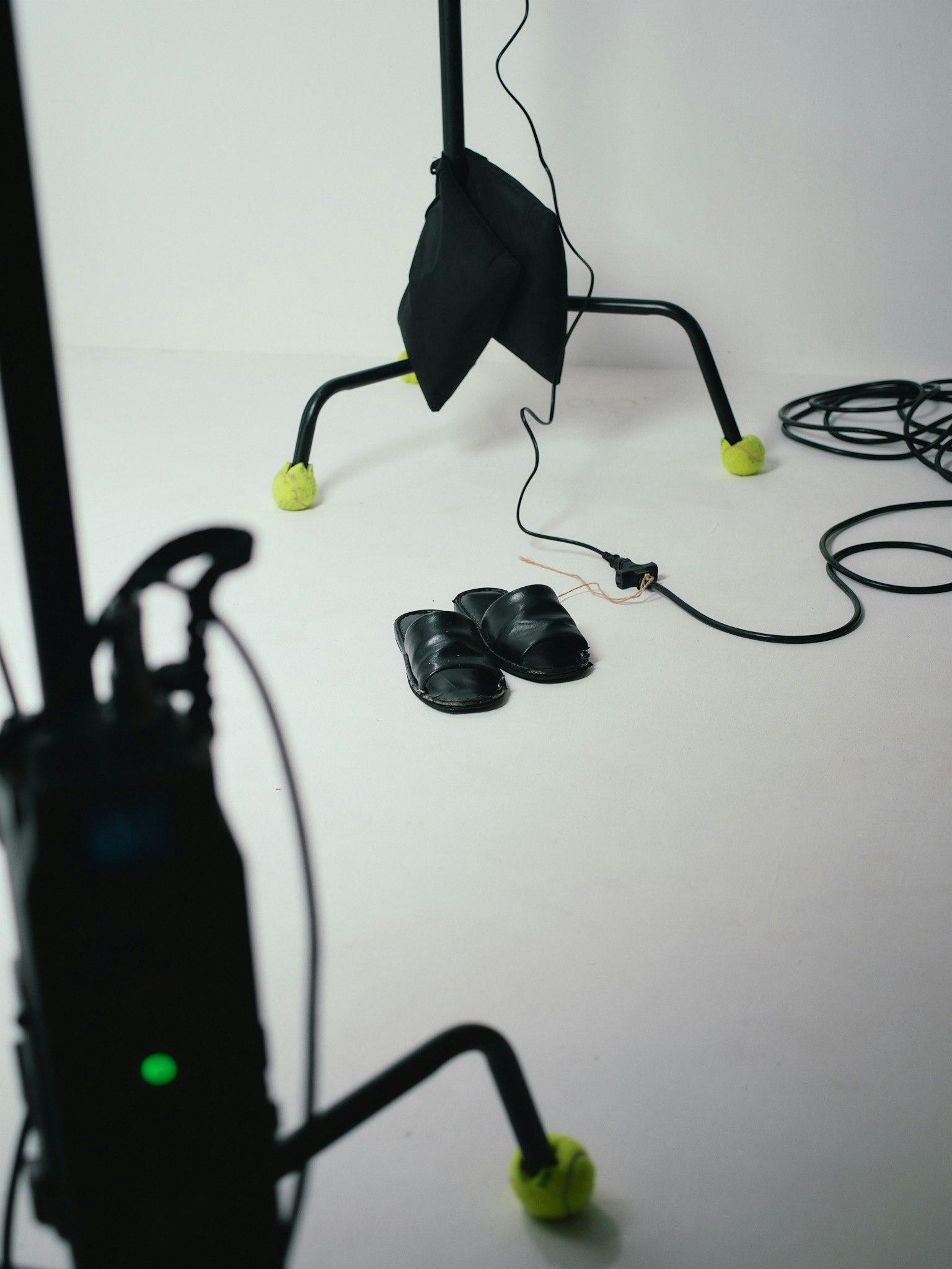 Una escena de estudio simple con zapatos negros y equipo sobre un fondo blanco