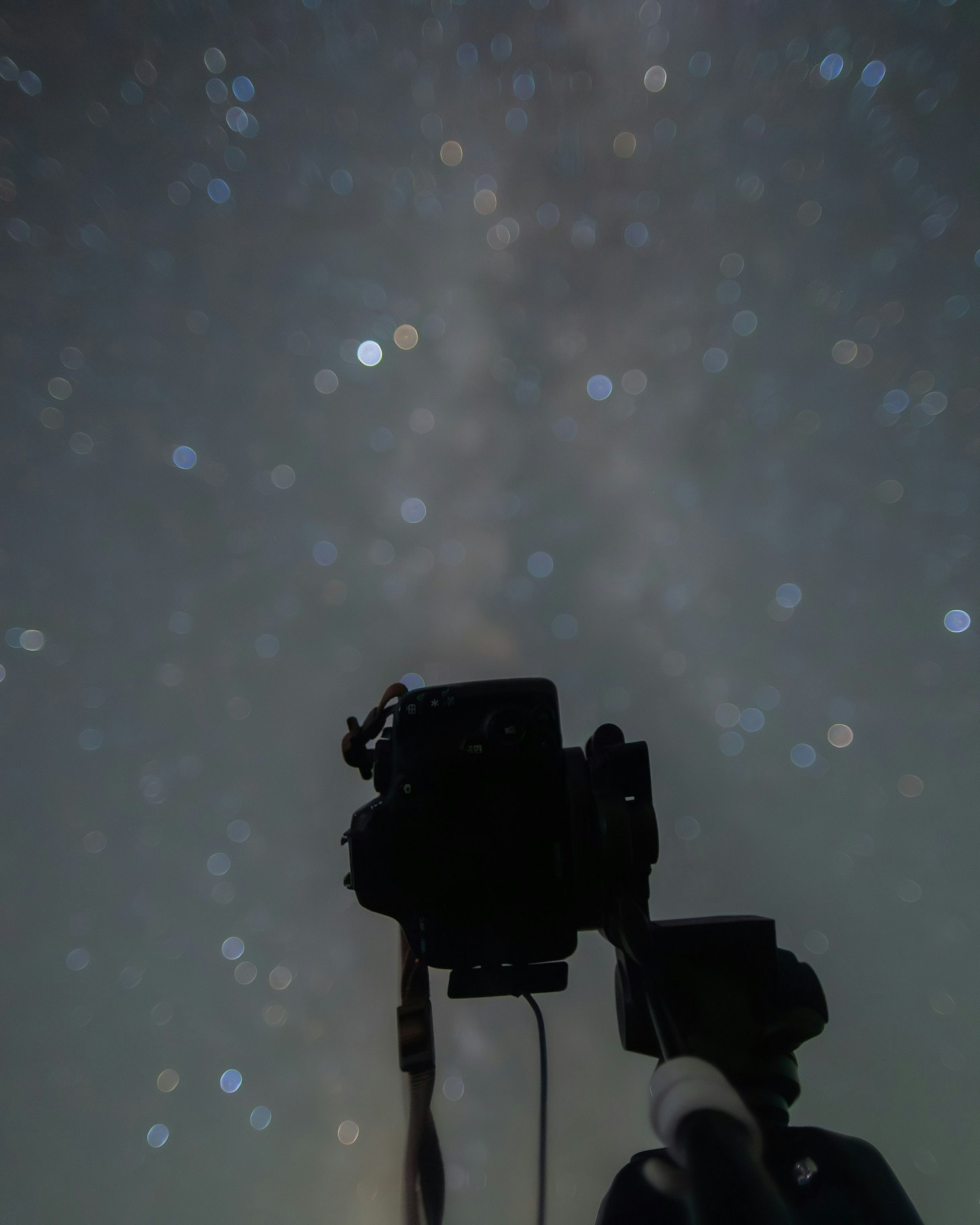 Silhouette kamera dan tripod di bawah langit berbintang