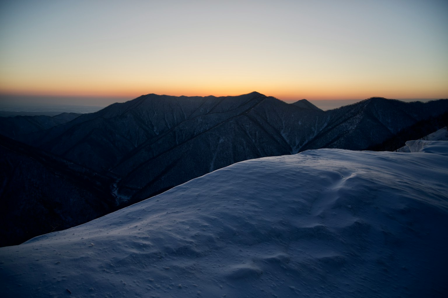 Belle vue du coucher de soleil depuis le sommet enneigé de la montagne