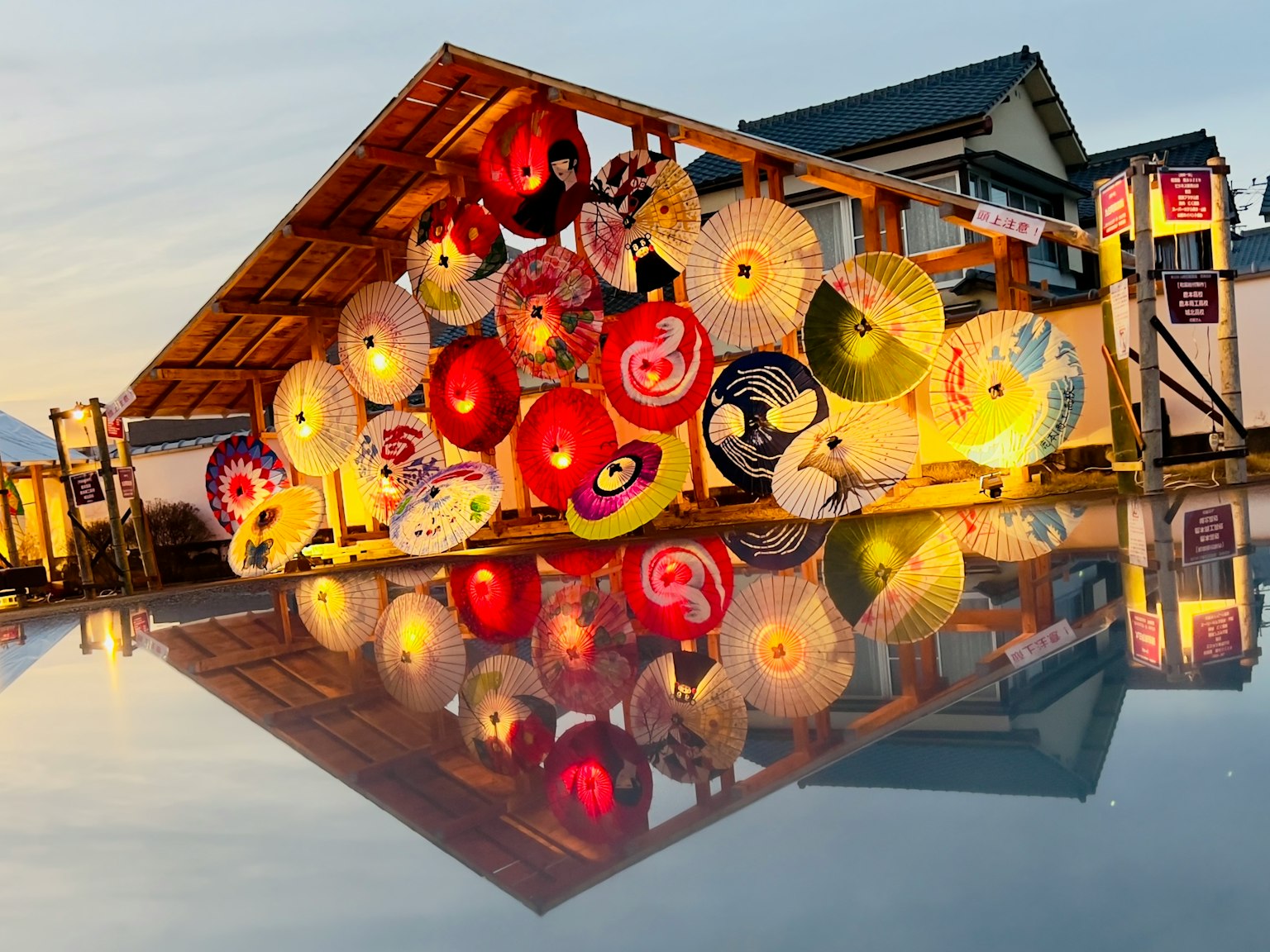 Colorful Japanese umbrellas displayed at a stall with reflections on the water surface
