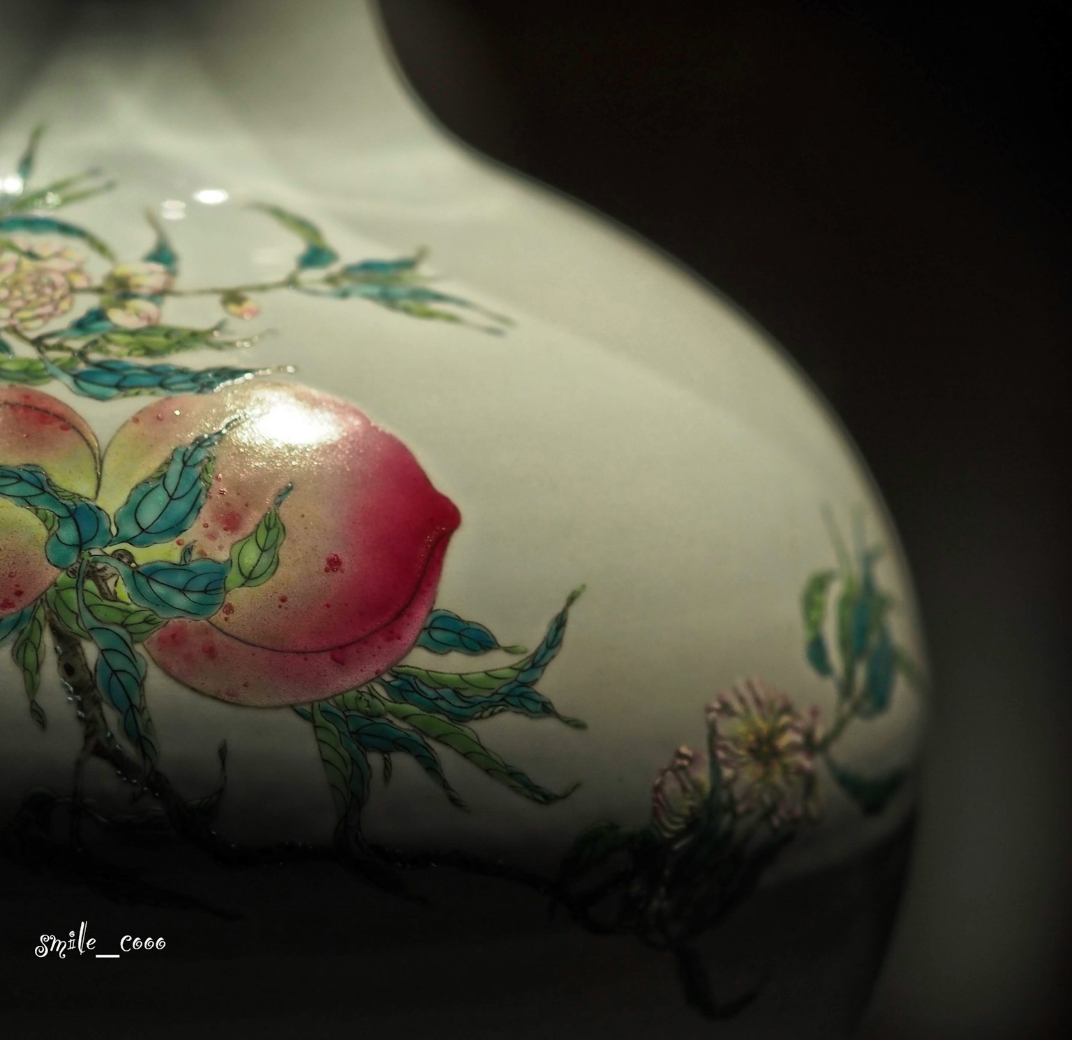 Detailed design of peach flowers and leaves on a white vase