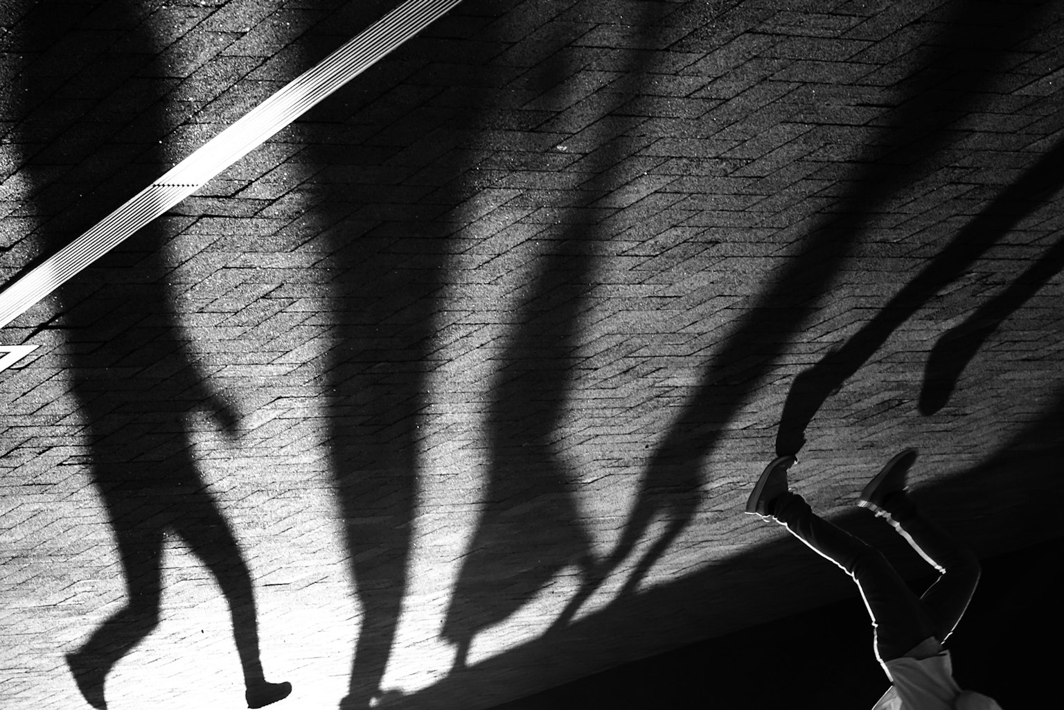 Schwarzweißbild von Menschen Schatten auf der Straße