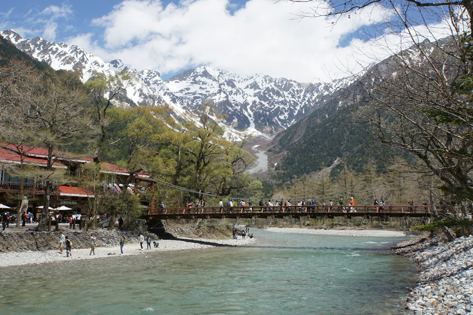 Malersicher Blick auf schneebedeckte Berge und einen Fluss unter einer Brücke