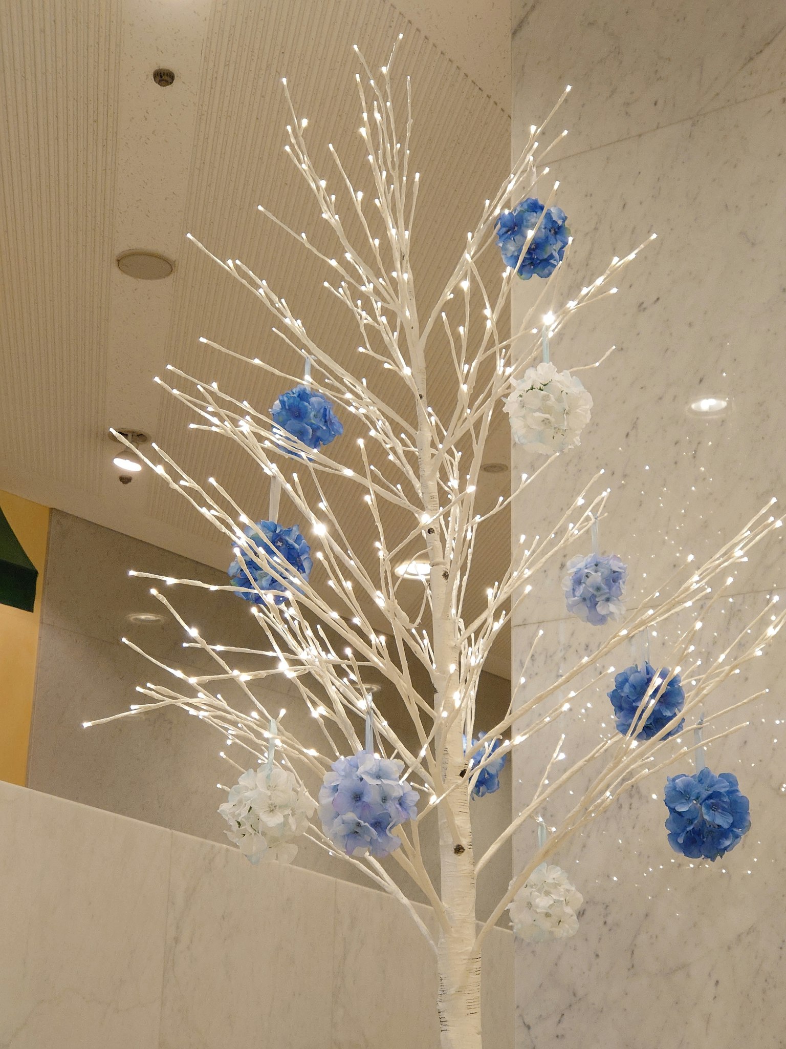 Albero decorativo bianco adornato con pompon blu e bianchi