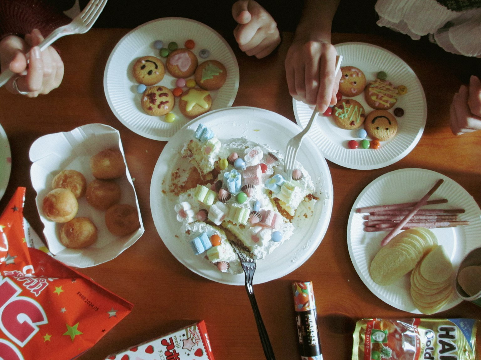 桌子上摆满了五颜六色的糖果和零食，几只手可见