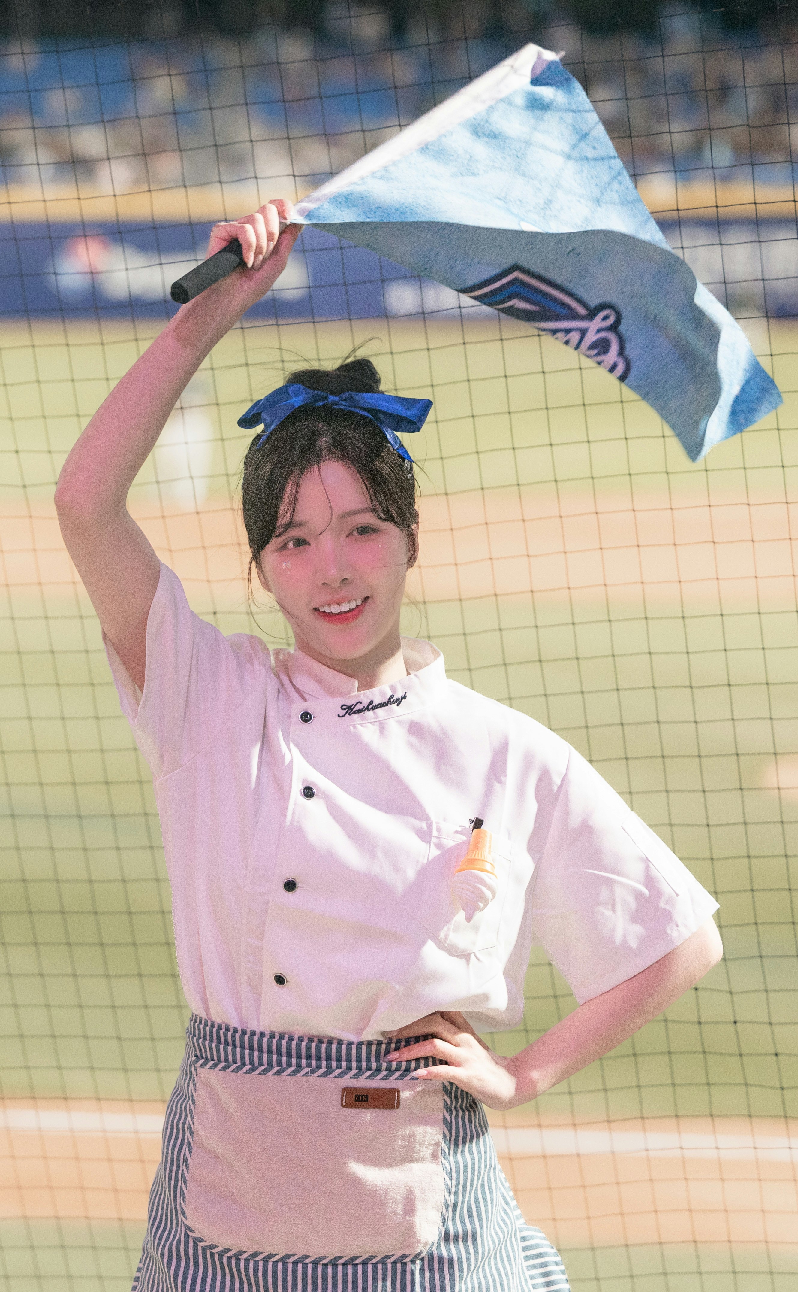 青空の下で旗を掲げる笑顔の女性