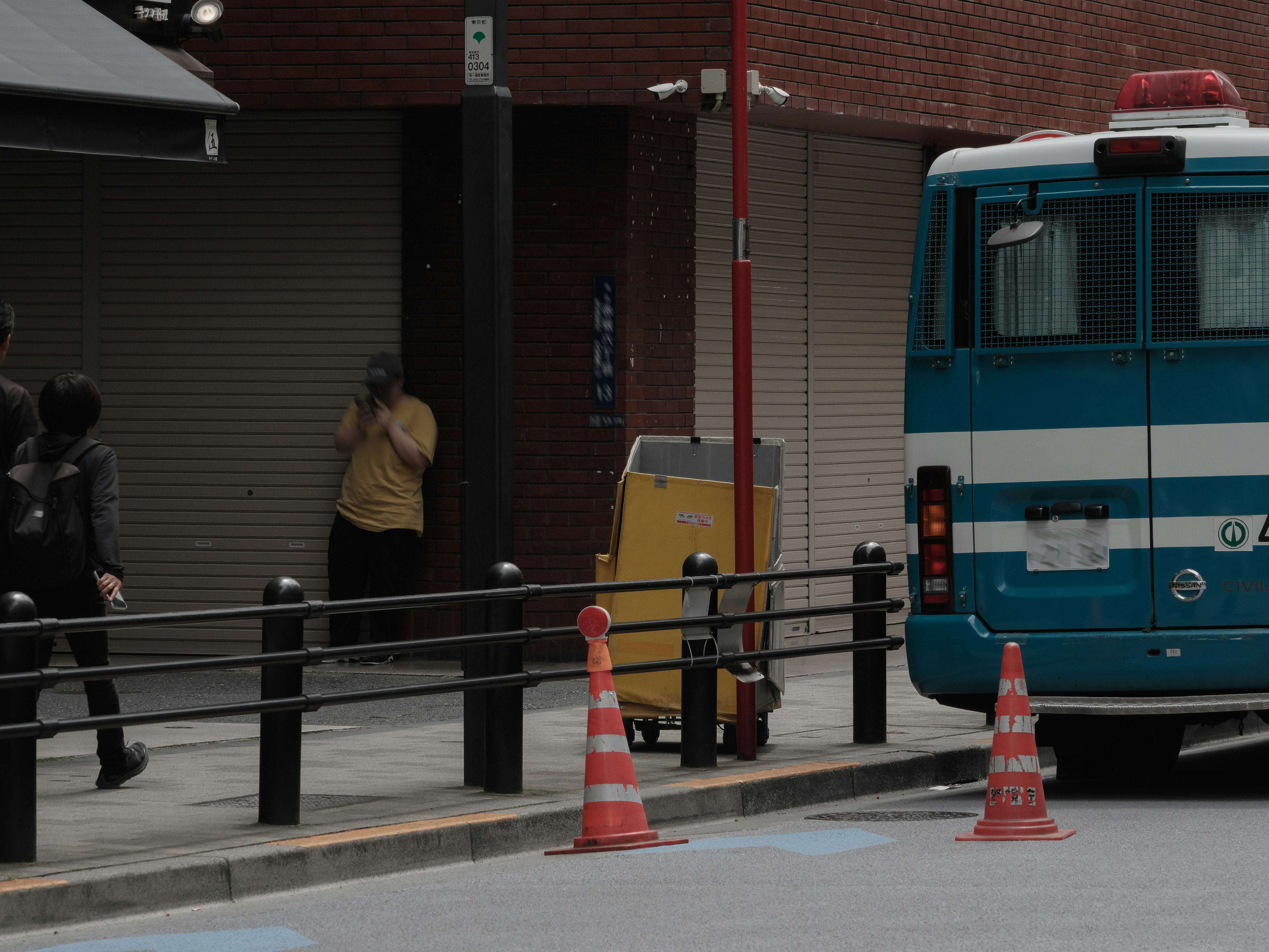 帶有黃色元素的城市街道場景：停靠的救護車與交通錐