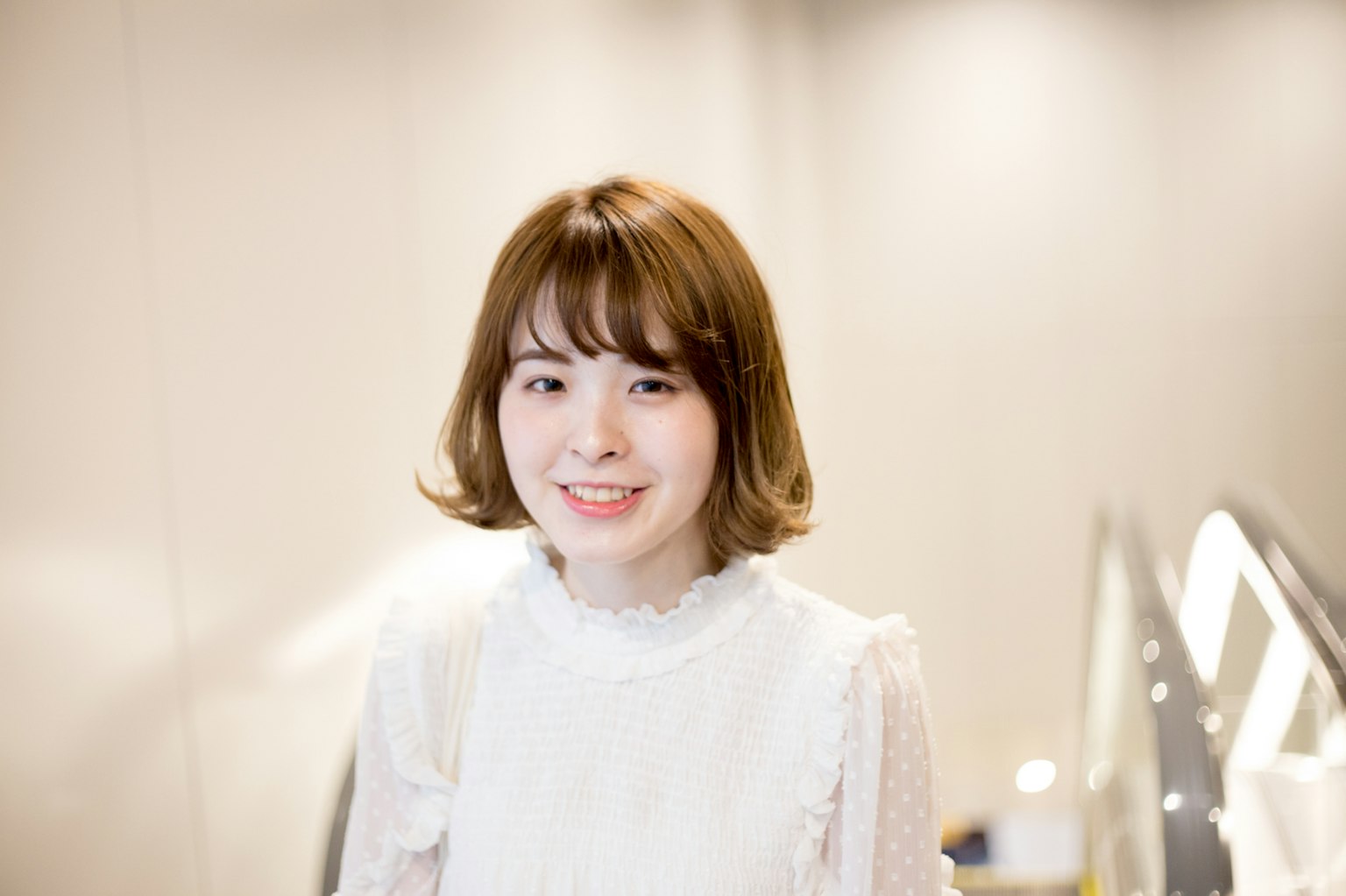 一位穿著白色上衣的年輕女性微笑著