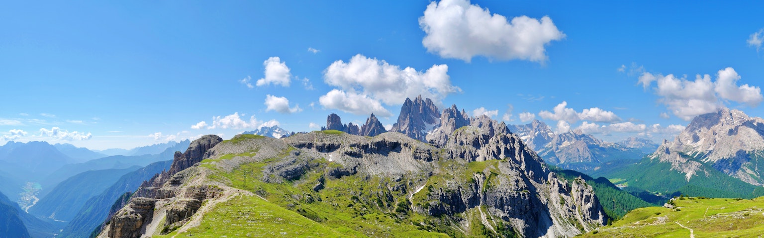 Atemberaubende Aussicht auf die Dolomiten mit blauem Himmel und grünen Wiesen