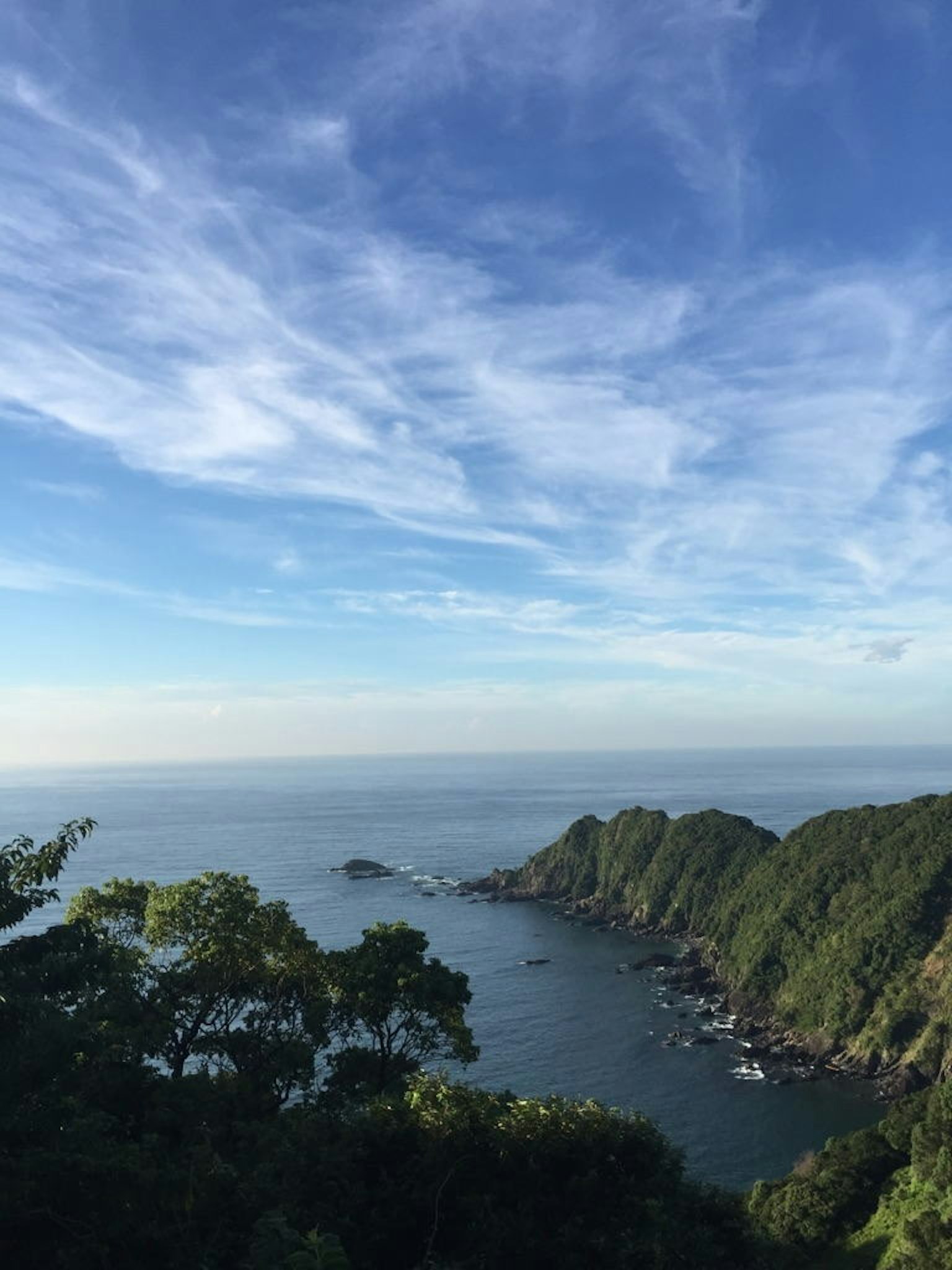 Costa panoramica con cielo blu colline verdi e mare tranquillo