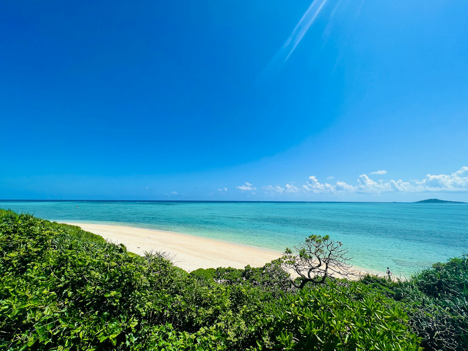 Scenic view of a beautiful beach with blue ocean and white sand
