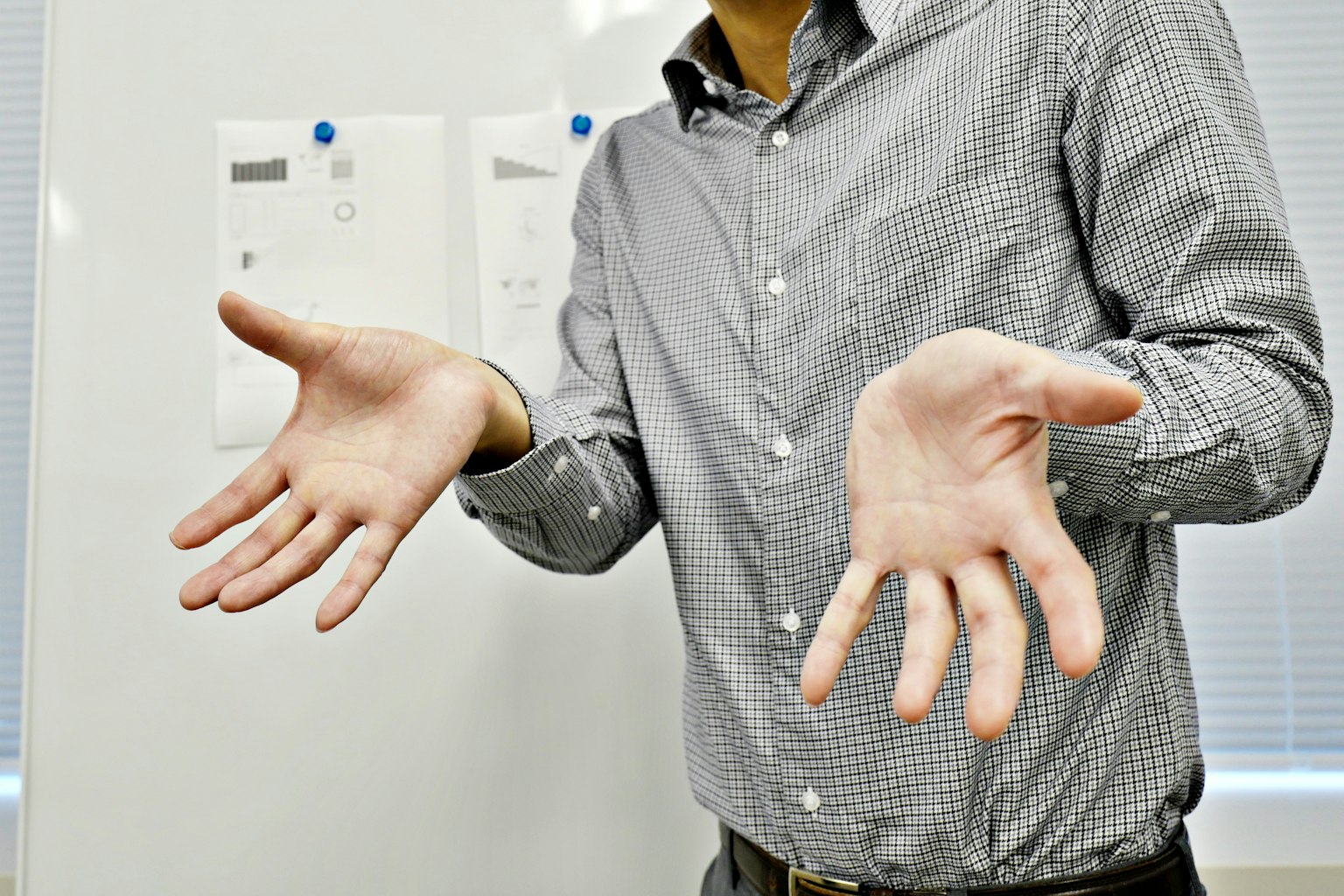 Un uomo con le mani aperte in un contesto lavorativo