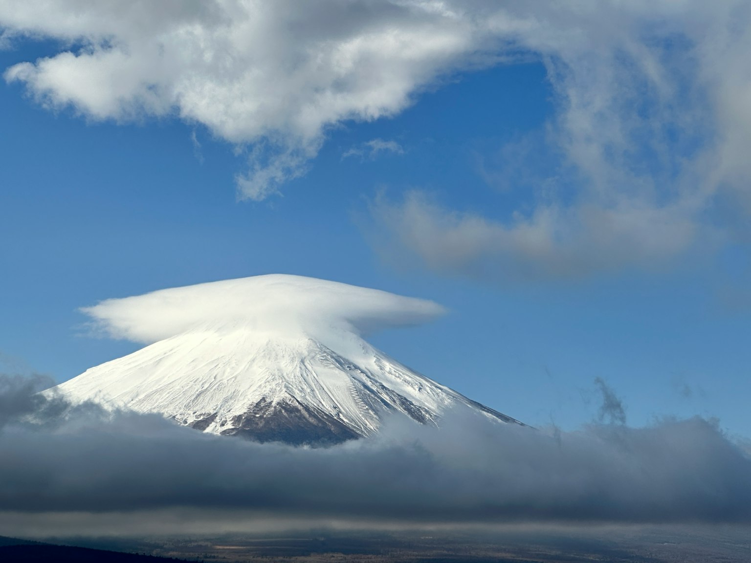 Mont Fuji enneigé avec un nuage en forme de chapeau
