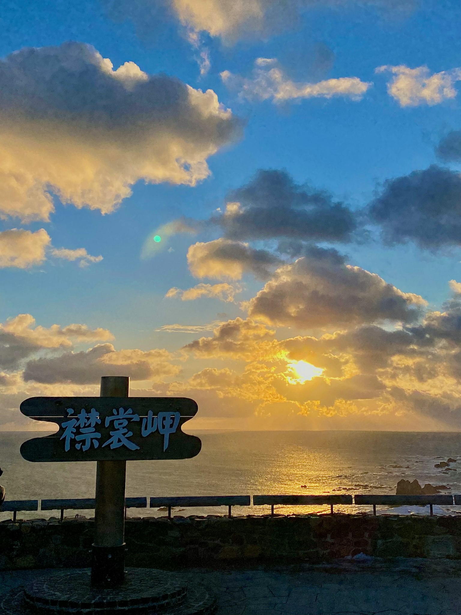 背景为海洋和日落的标志牌