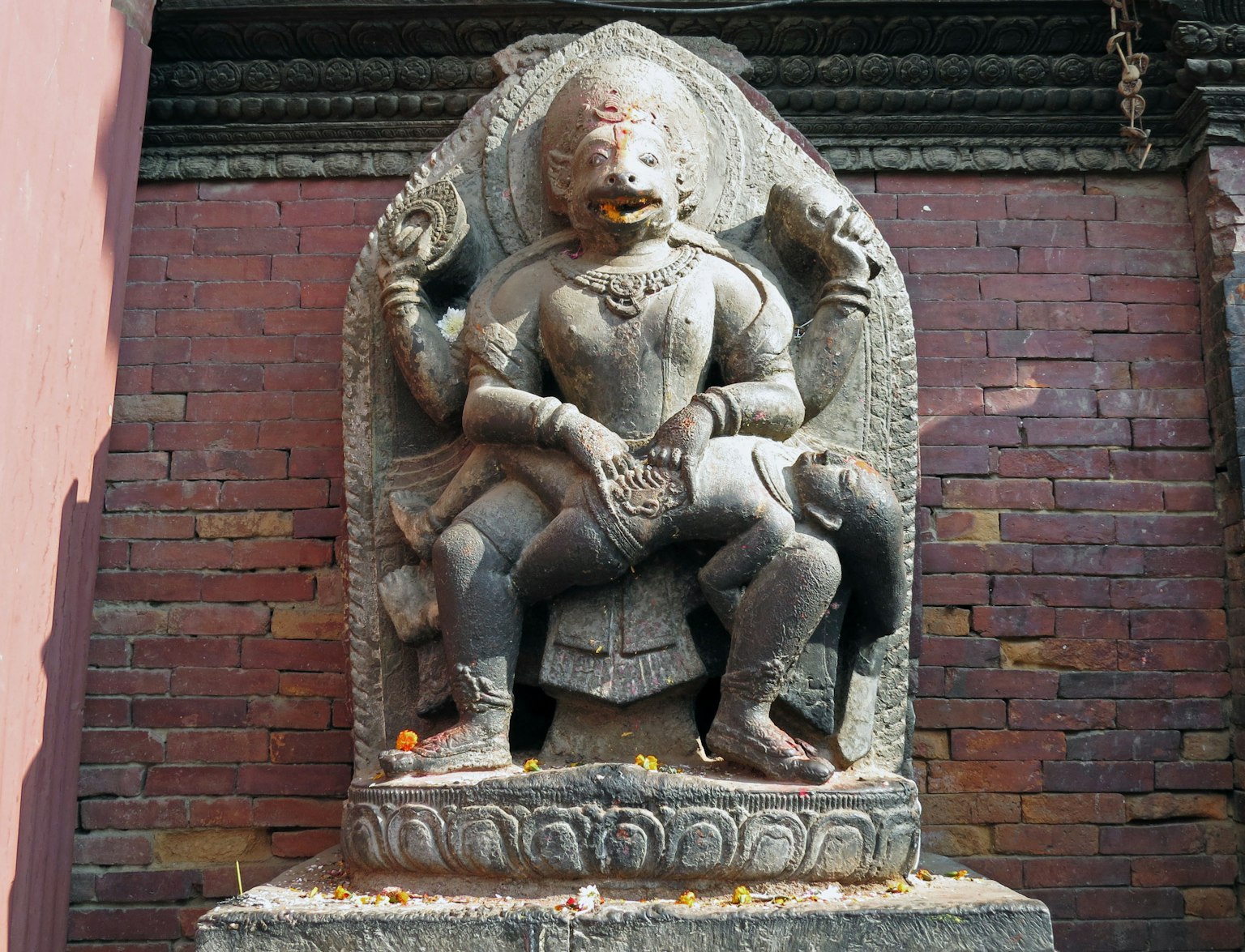 Scultura in pietra di una divinità seduta su un trono