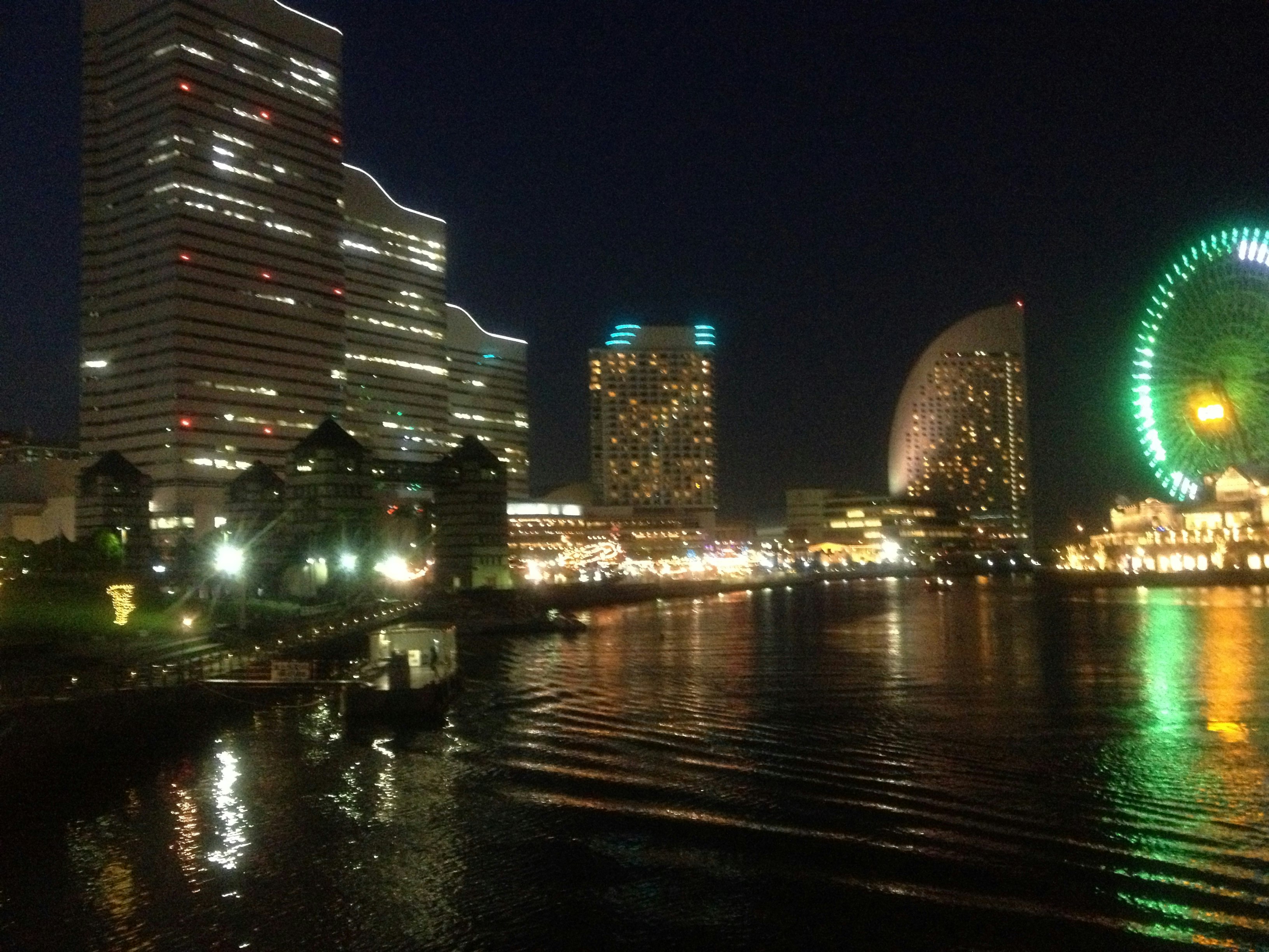 夜の川沿いに並ぶ高層ビルとネオンの街並み