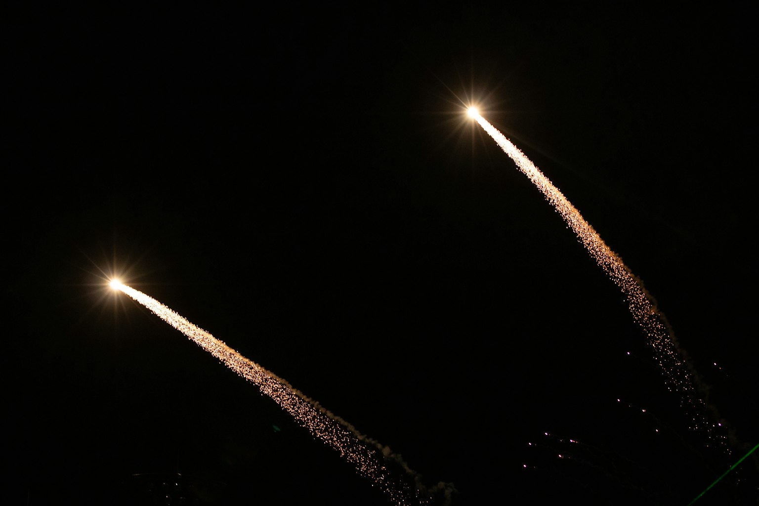 夜空中兩枚火箭飛行，留下火花軌跡