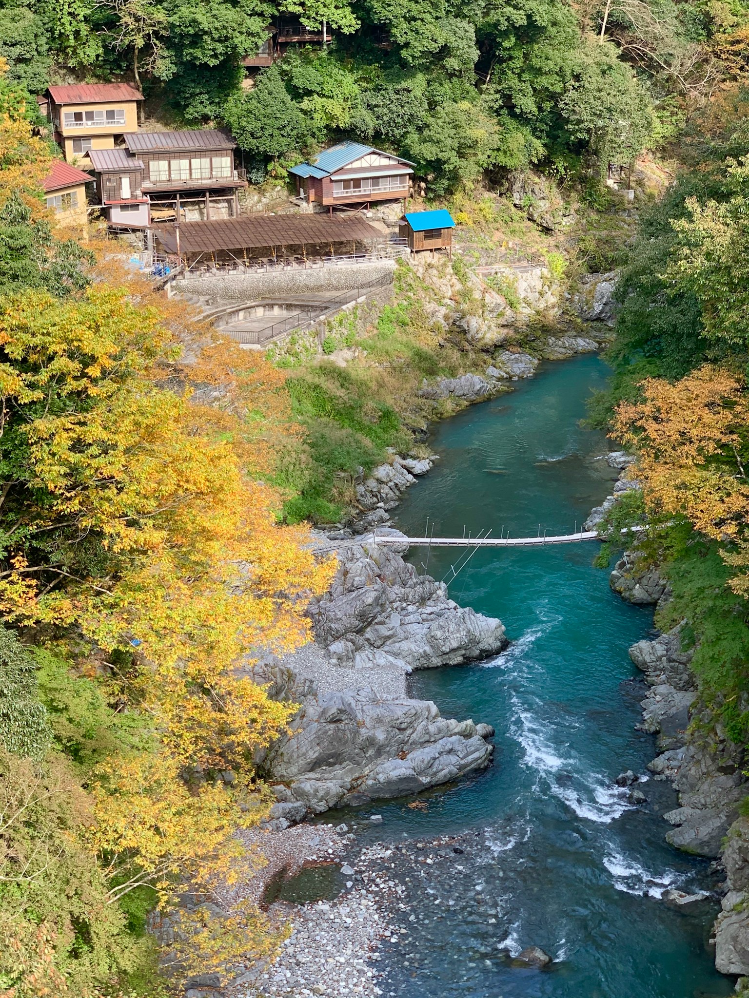 Vista panoramica di un edificio tradizionale circondato da foglie autunnali e un fiume