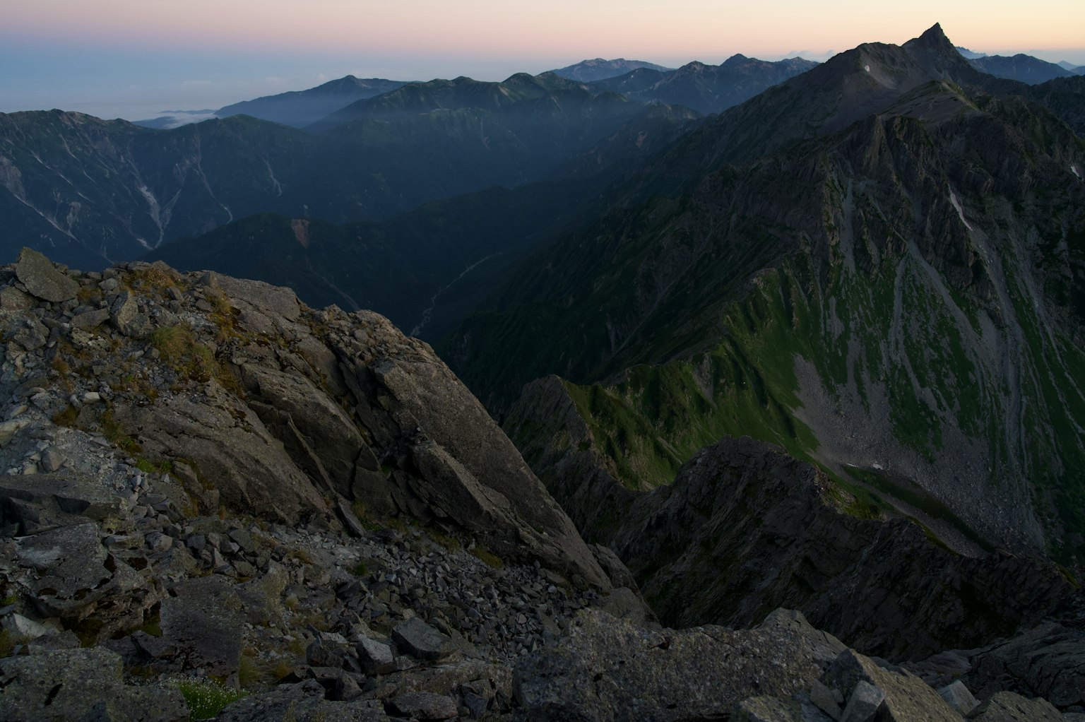 從山頂的視角，岩石坡和遠處的山峰