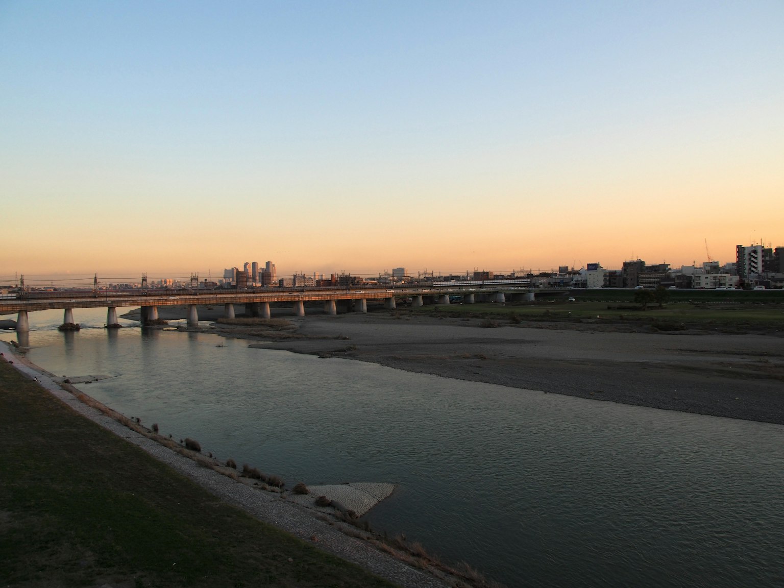 Vue pittoresque d'une rivière au coucher du soleil avec un pont