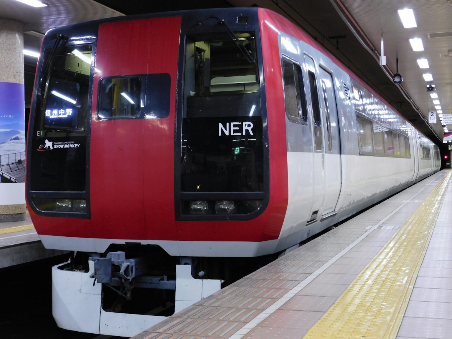 Tren rojo y blanco detenido en el andén de la estación