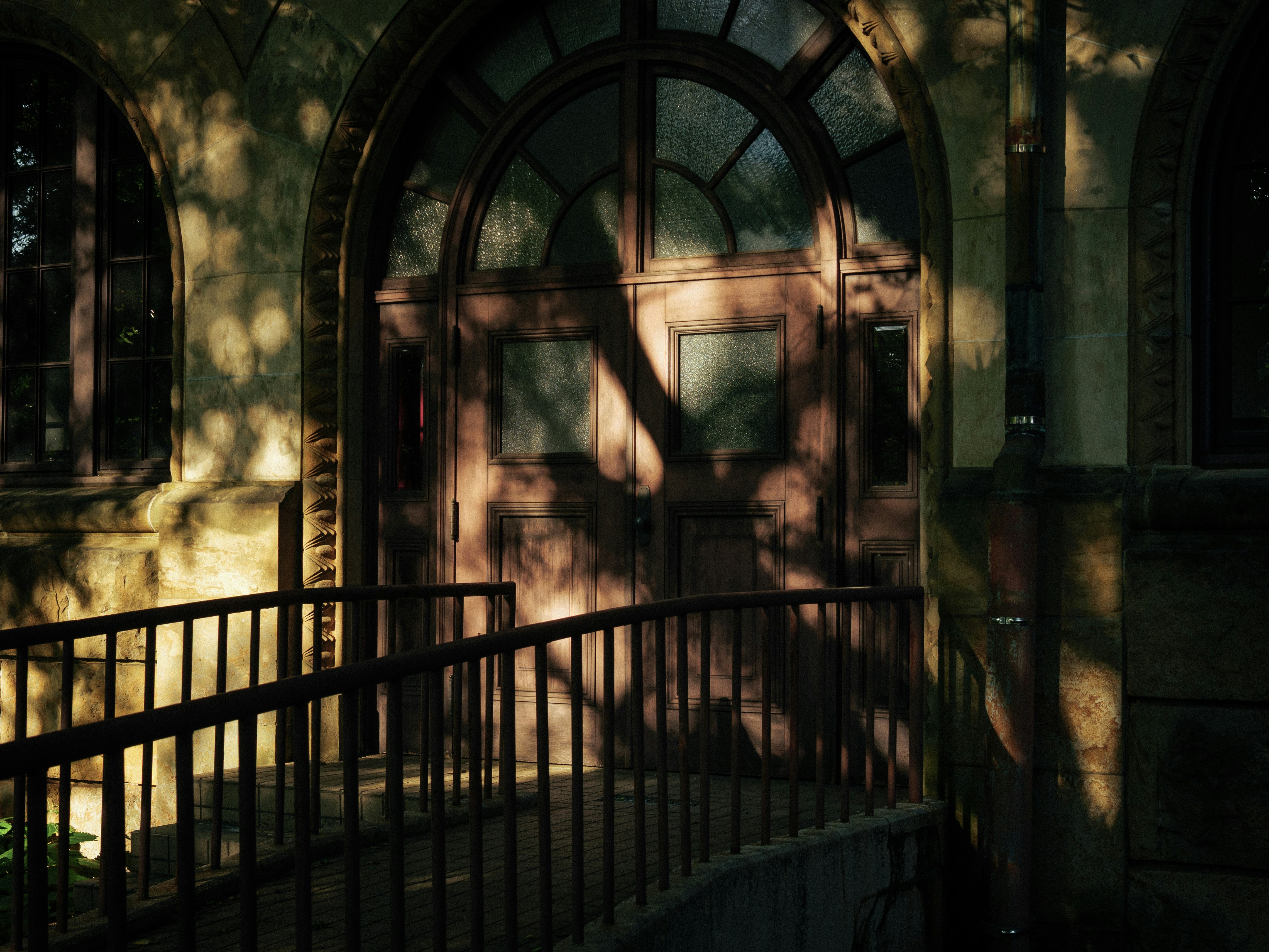 初夏の光が差し込むアーチ型のドアのある玄関