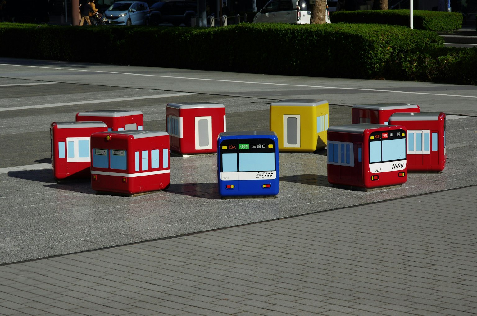 Colorful bus-shaped objects arranged in a park setting