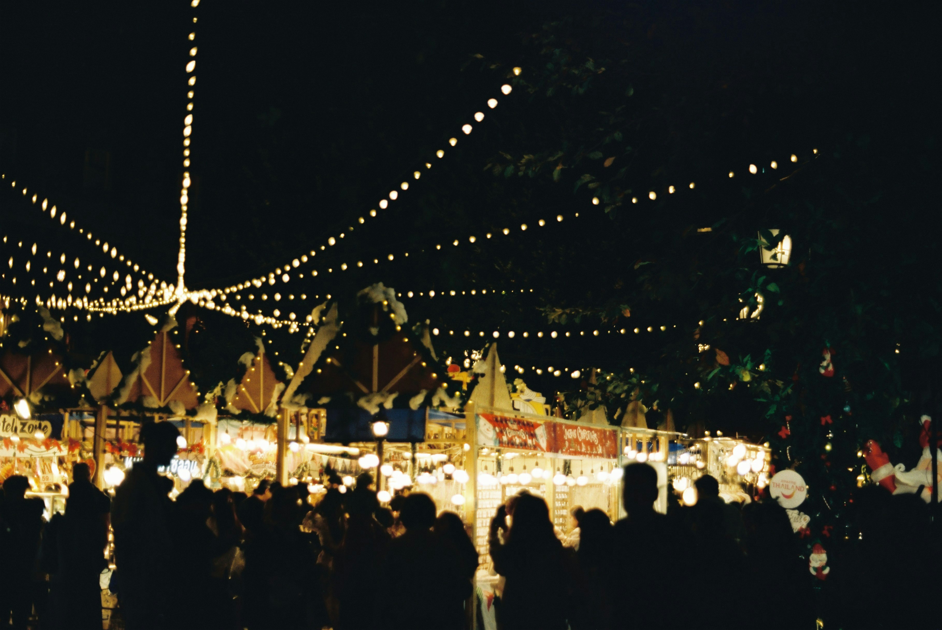 nighttime street market with rows of stalls and warm lights