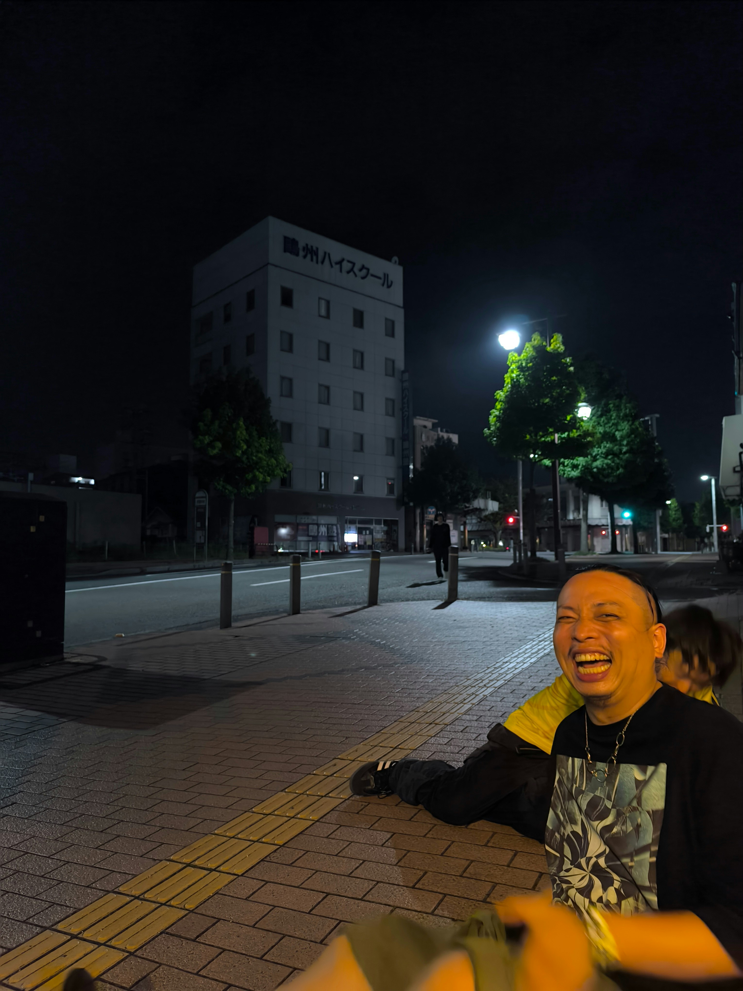夜の街角で笑う人と街灯の光