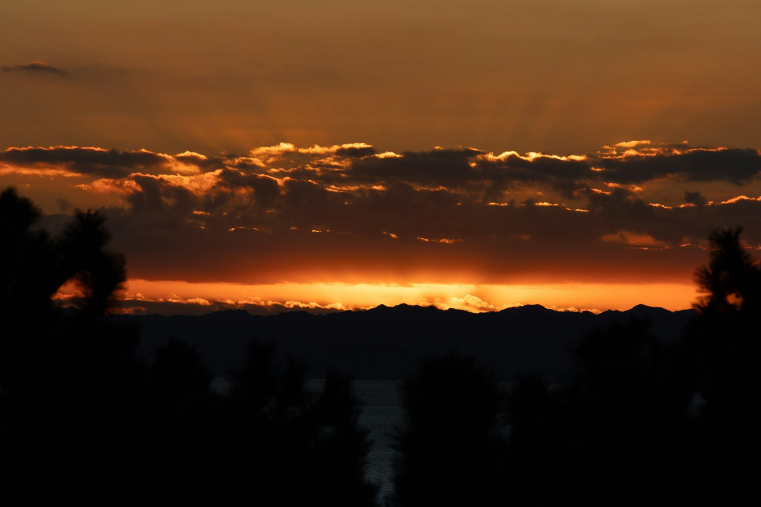 Bellissimo paesaggio al tramonto con montagne in silhouette