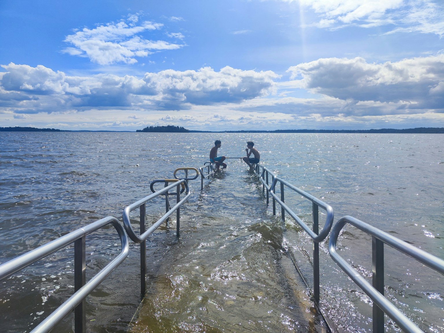Due persone in bicicletta su un molo sopra l'acqua