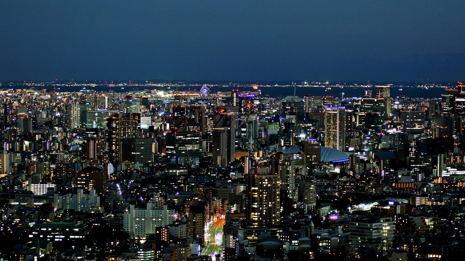 Night cityscape with illuminated skyscrapers and vibrant lights