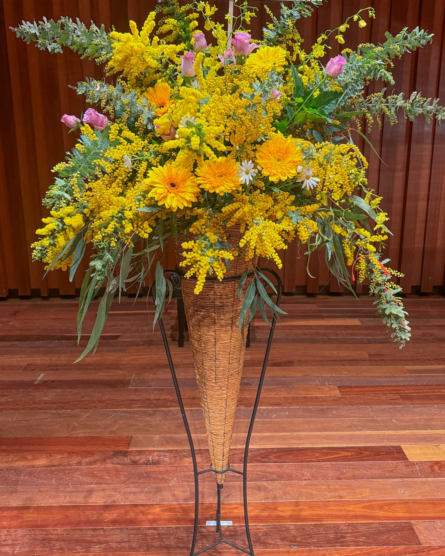 A vibrant bouquet of yellow and purple flowers arranged in a decorative vase