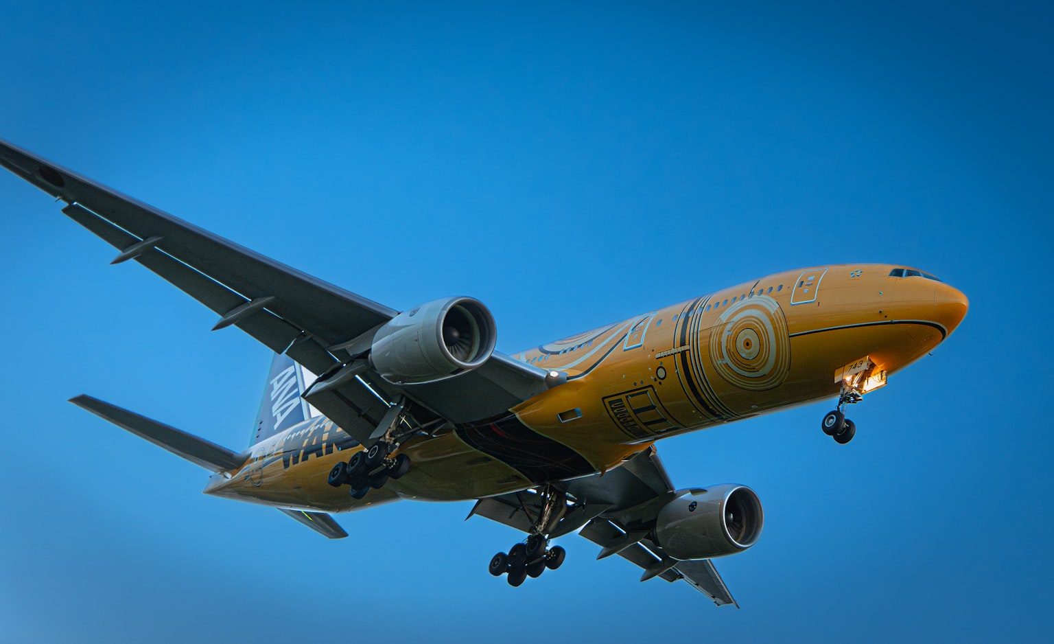Un aereo passeggeri giallo che vola contro un cielo blu