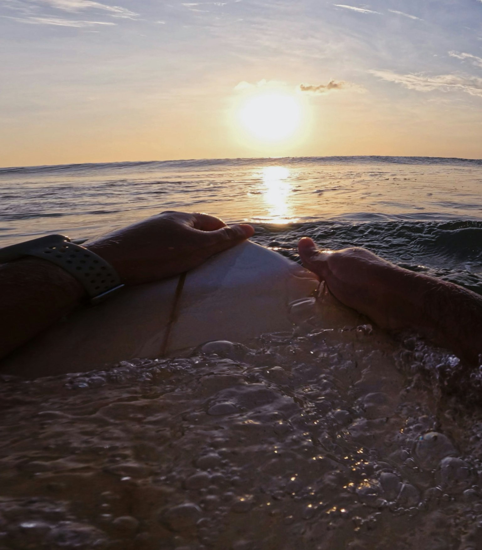 Escena de surf con el atardecer de fondo sobre el océano