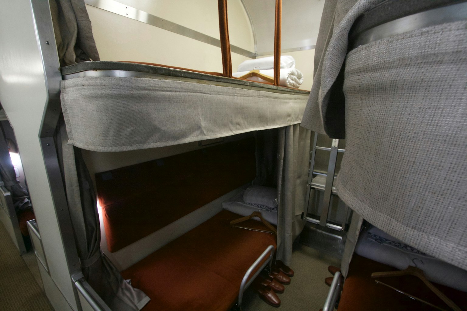 Interior view of bunk beds with visible bedding and hangers
