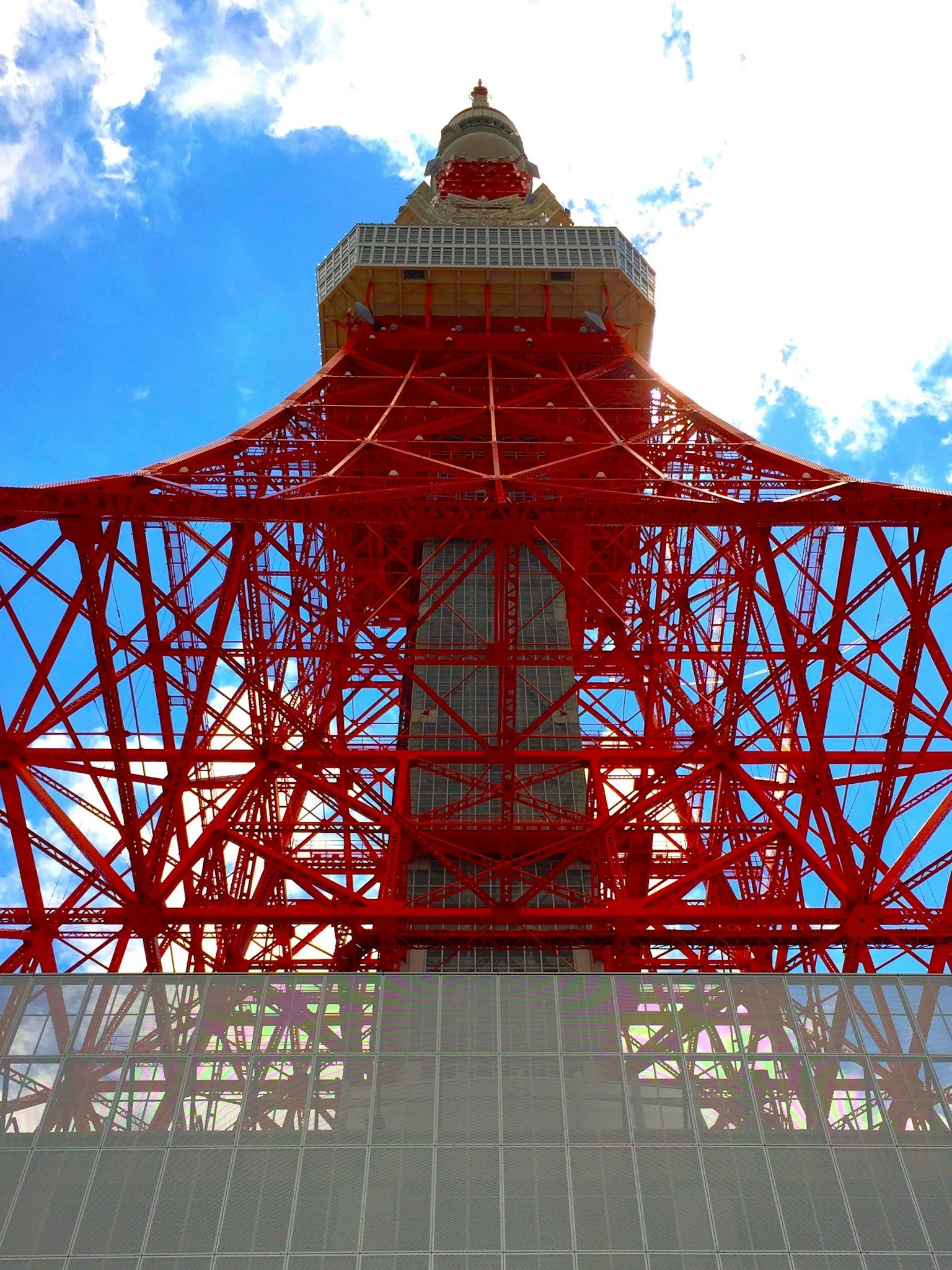 Vista desde abajo de la Torre de Tokio mostrando su estructura roja contra un cielo azul