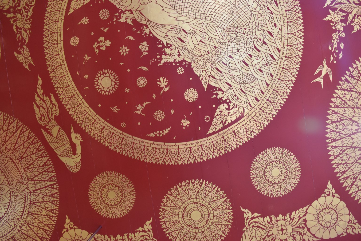 Red background with intricate gold circular patterns and floral designs