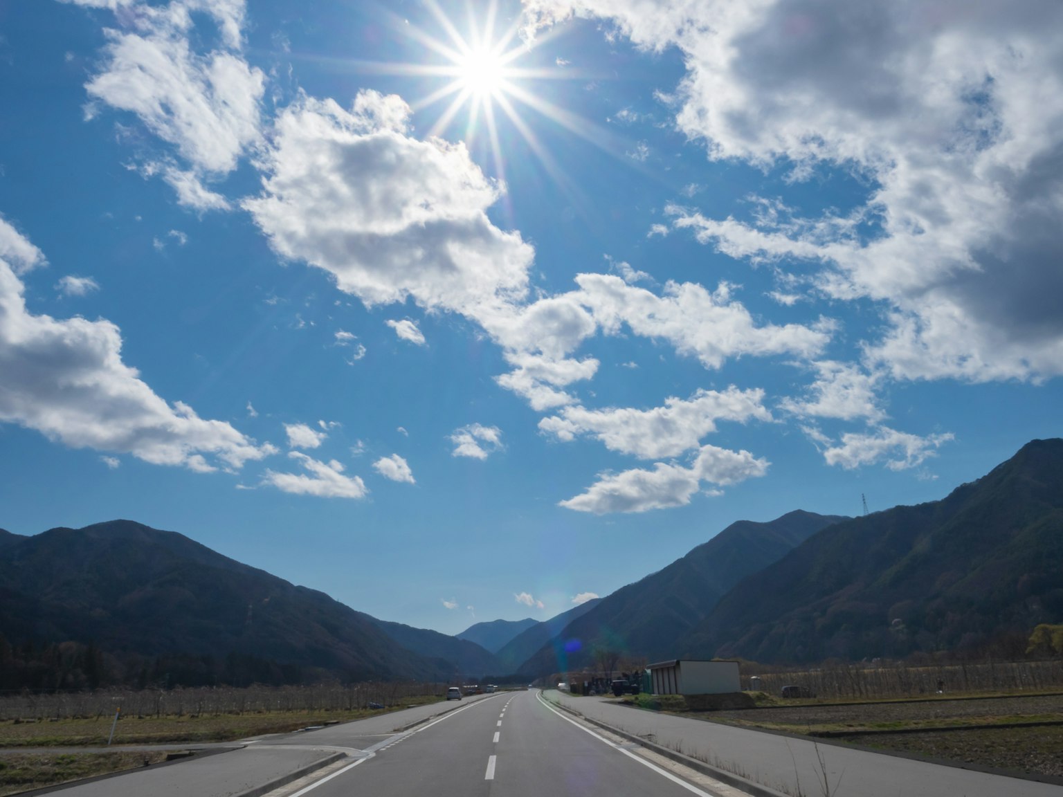 Mountain road with blue sky and clouds