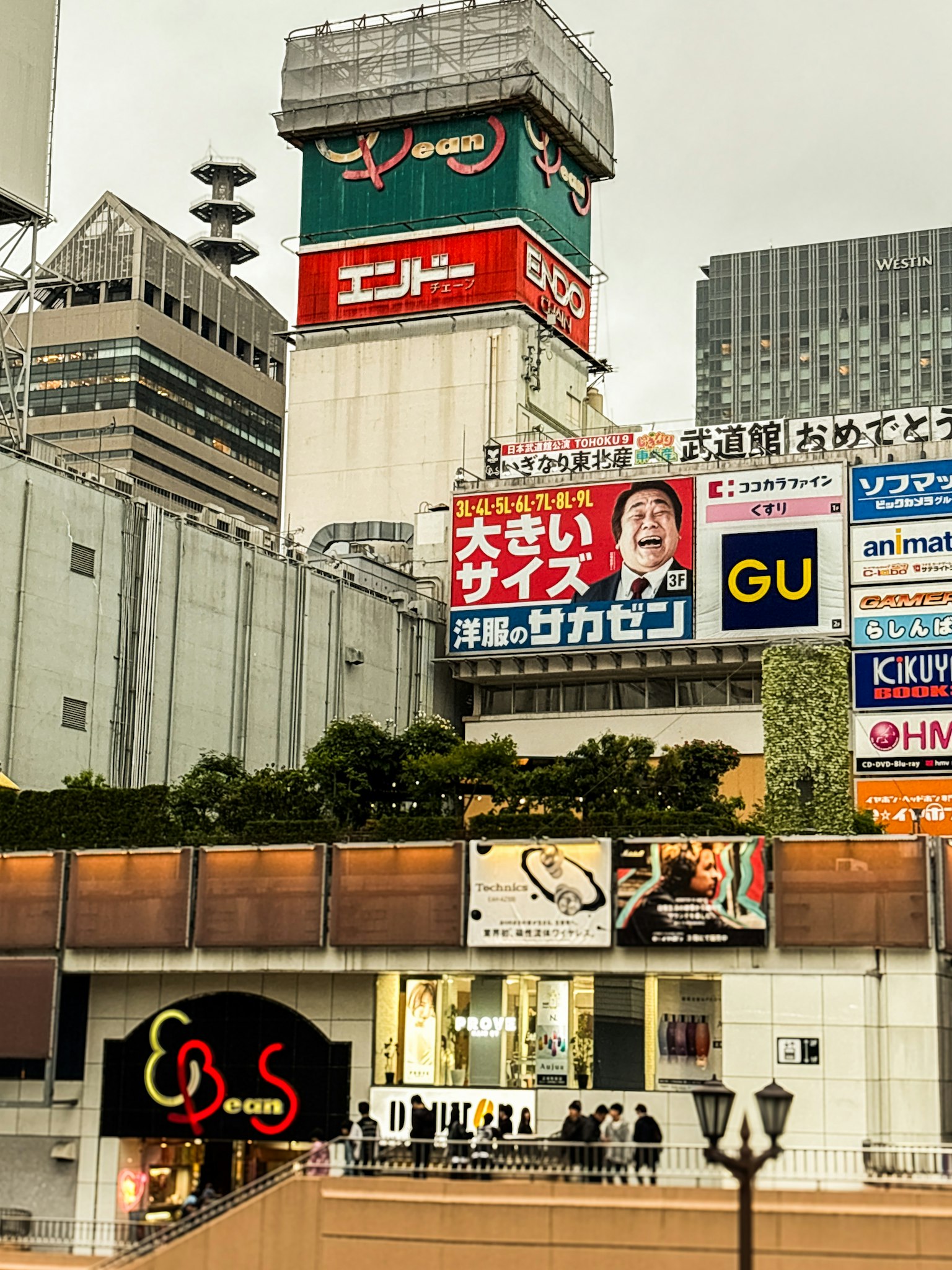 Außenansicht eines Geschäftsgebäudes in Shibuya mit großen Werbeanzeigen und Beschilderungen
