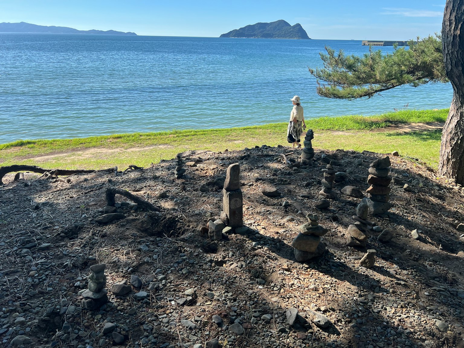 海の近くに立つ人物と石の構造物がある風景