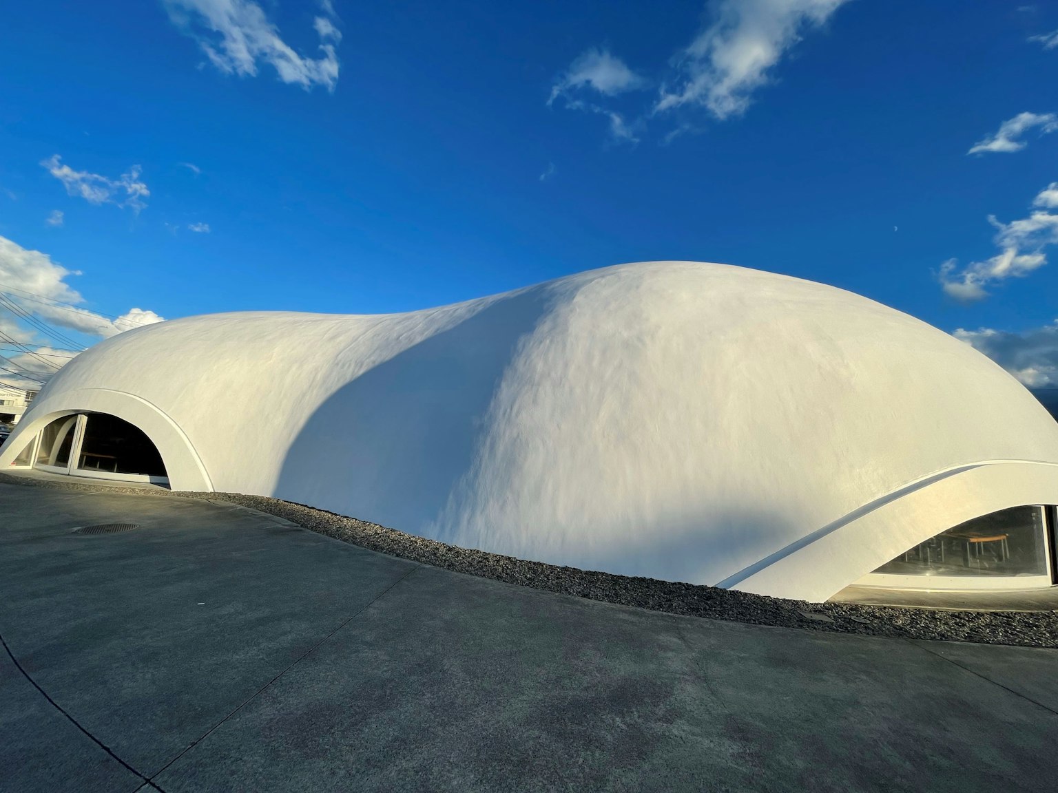 Bâtiment blanc courbé sous un ciel bleu